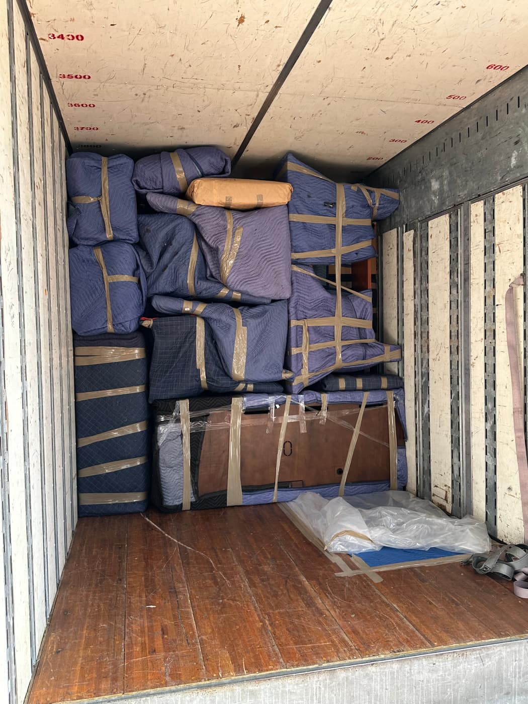 Blanket-wrapped pieces strapped into the truck