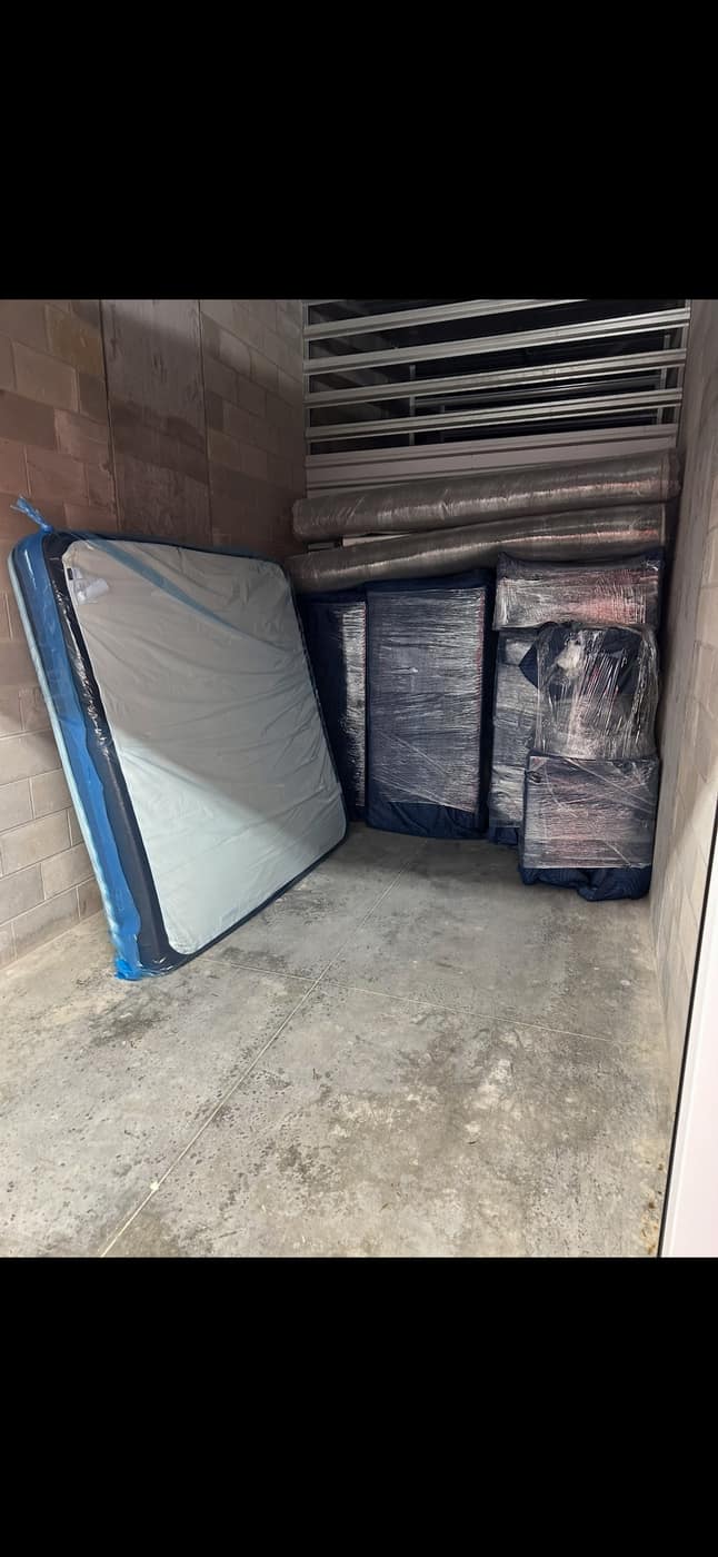 Mattress and wrapped items staged in storage