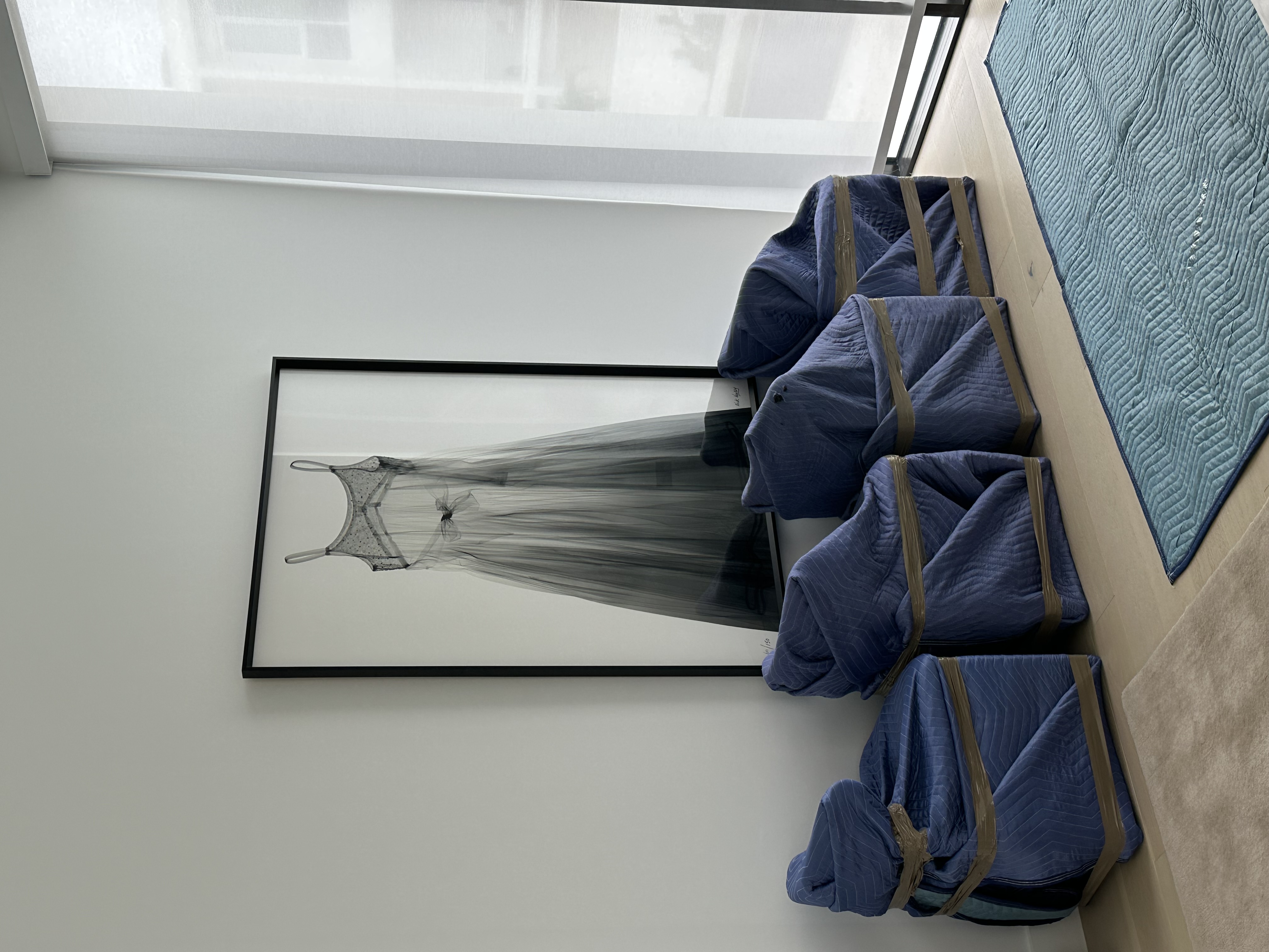 Furniture wrapped in moving blankets and staged beside protected flooring