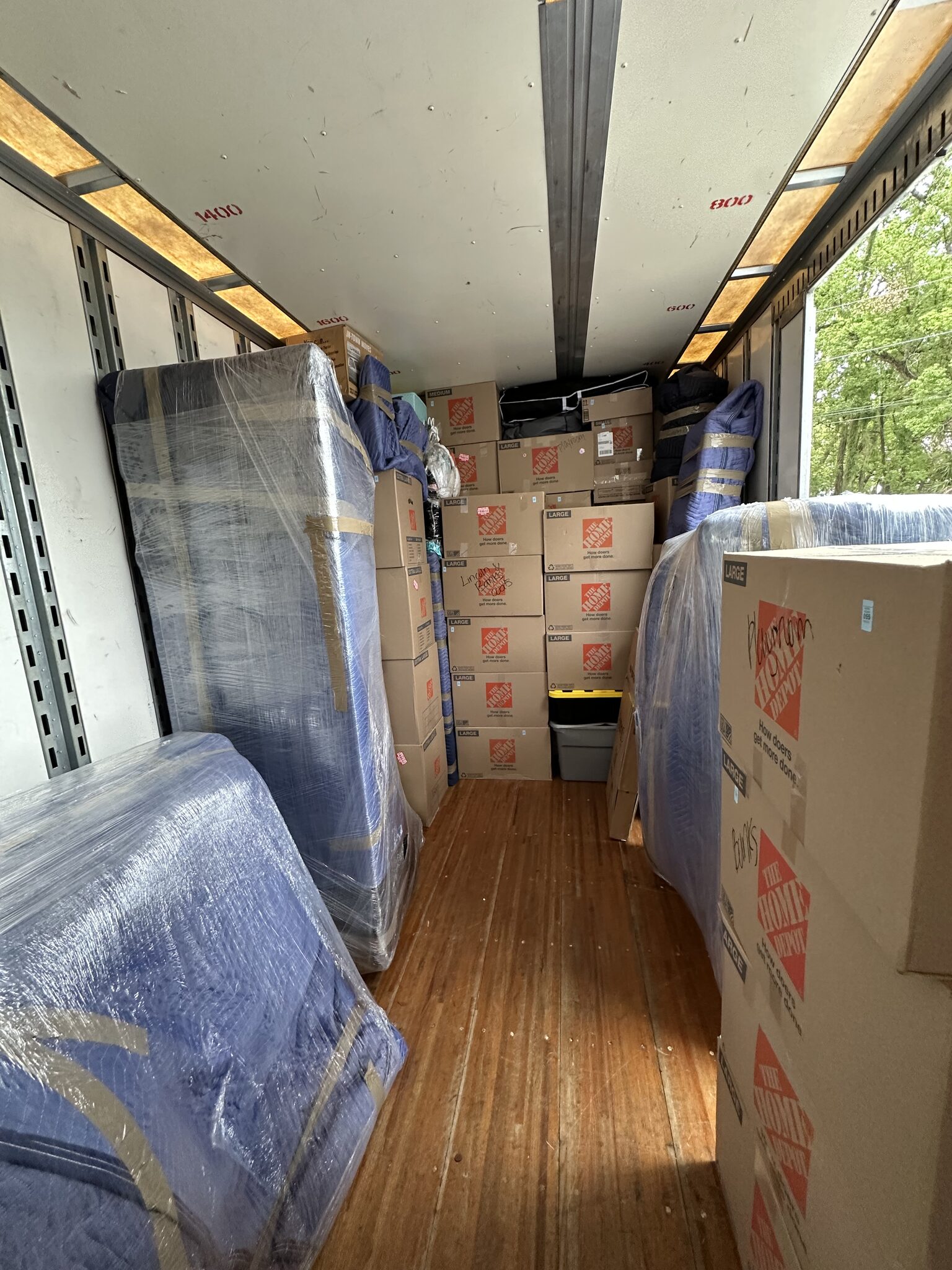 Truck loaded with blanket-wrapped furniture and neatly stacked moving boxes